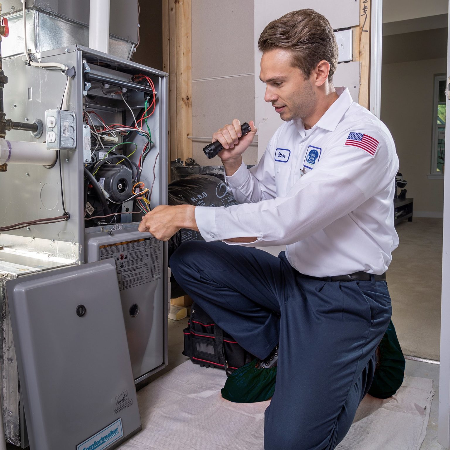 Experienced HVAC technician testing air conditioning components with diagnostic tools indoors