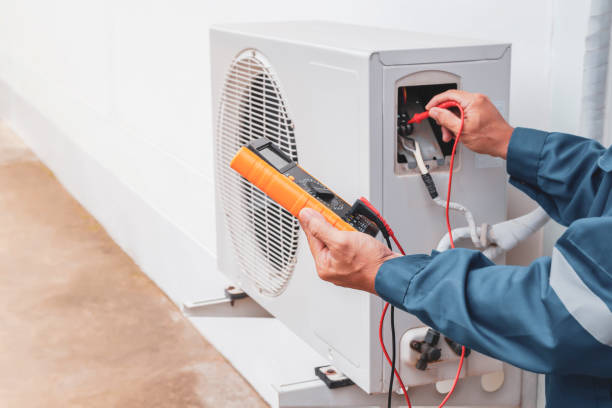 Technician diagnosing failed air conditioner at Tampa home during afternoon heat