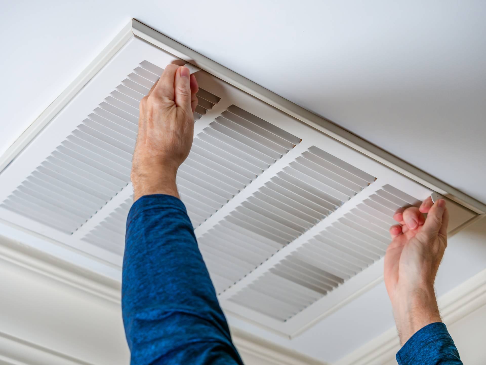 Specialist inspecting indoor air components and filtration system for balanced airflow