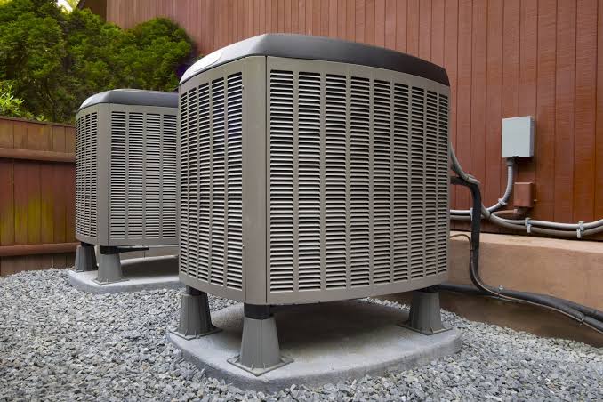 Technician installing new indoor HVAC unit in Tampa residential utility closet