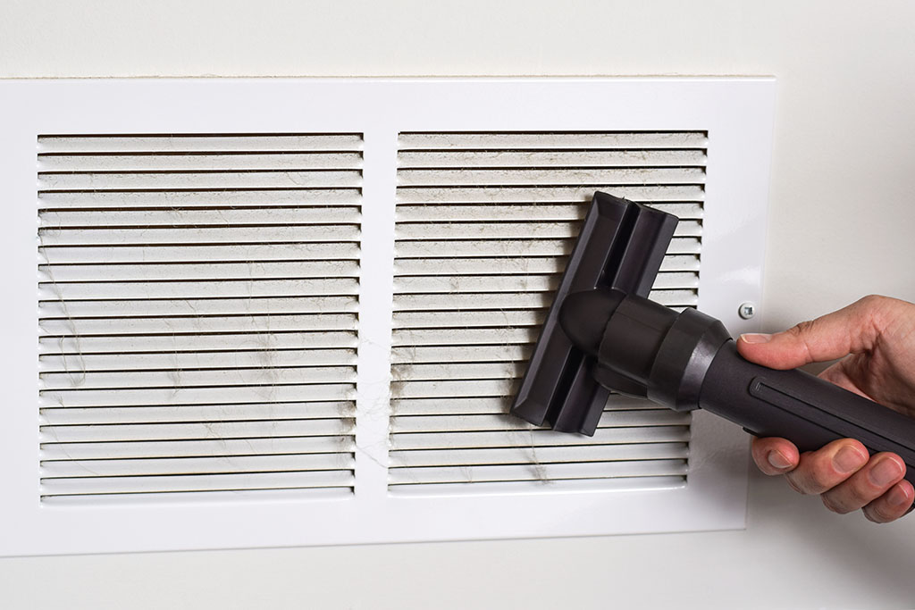 Specialist inspecting indoor air components and filtration system for balanced airflow