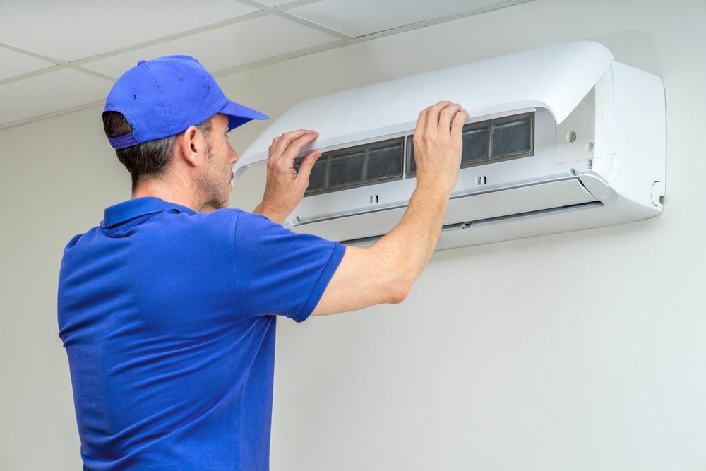 HVAC installer measuring airflow and checking system connections during equipment setup