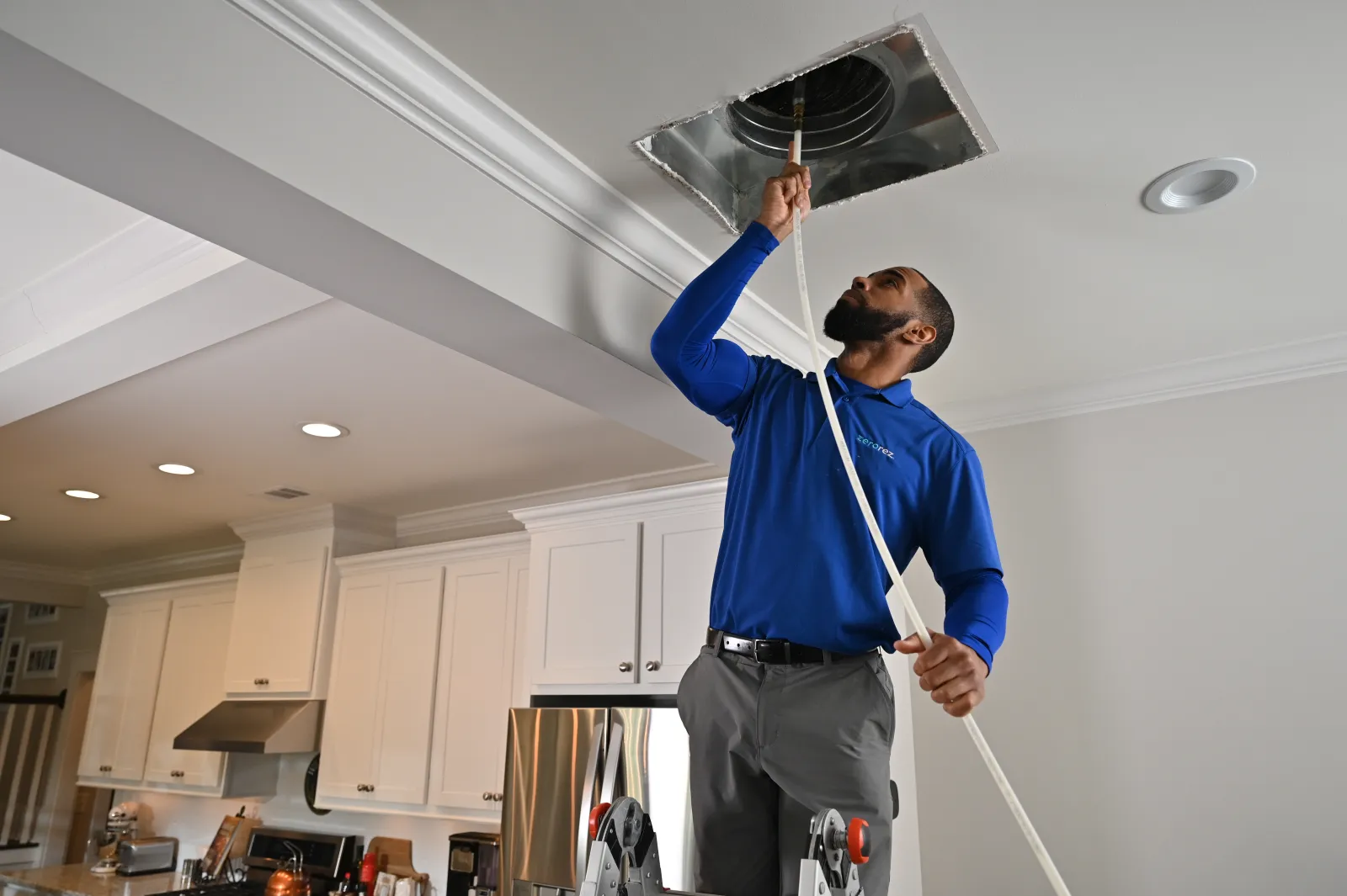 HVAC specialist inspecting interior ductwork with tools to identify heavy dust accumulation
